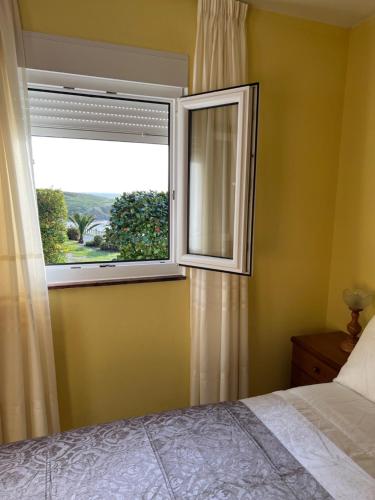 1 dormitorio con ventana y cama en Apartamento Playa de Lires, en Cee