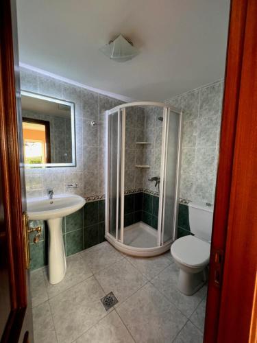 y baño con ducha, lavabo y aseo. en Apartamento Playa de Lires, en Cee