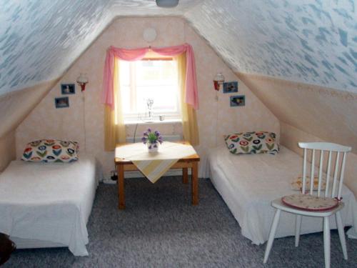 エーケレーにあるThree-Bedroom Holiday home in Skåのベッド2台、テーブル、窓が備わる客室です。