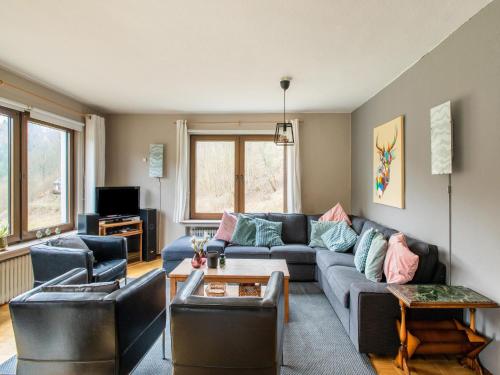 a living room with a blue couch and chairs at Spacious holiday home with private terrace in Schmallenberg
