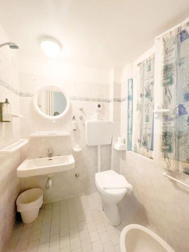 La salle de bains blanche est pourvue de toilettes et d'un lavabo. dans l'établissement Hotel villa del bagnino, à Rimini
