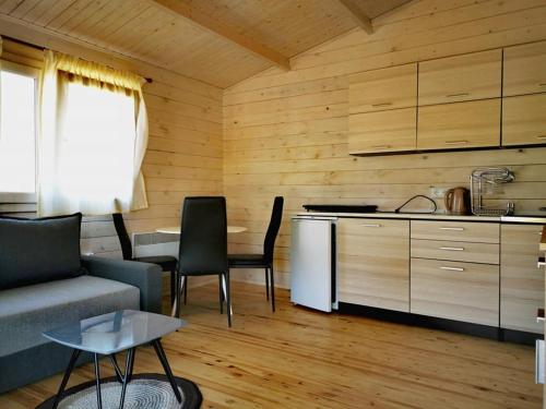 eine Küche und ein Wohnzimmer mit einem Sofa und einem Tisch in der Unterkunft Park Rio in Łukęcin