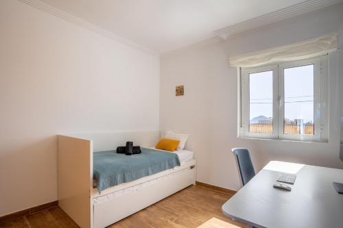 a bedroom with a bed and a desk and a window at Villa Arizona - 3-bedroom house by the sea in El Médano