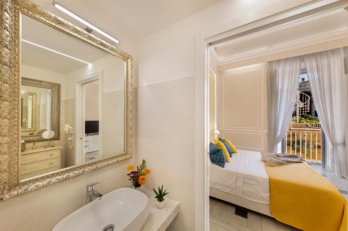 uma casa de banho com um espelho, uma cama e um lavatório. em YourHome - Royal Blue Suite em Sorrento