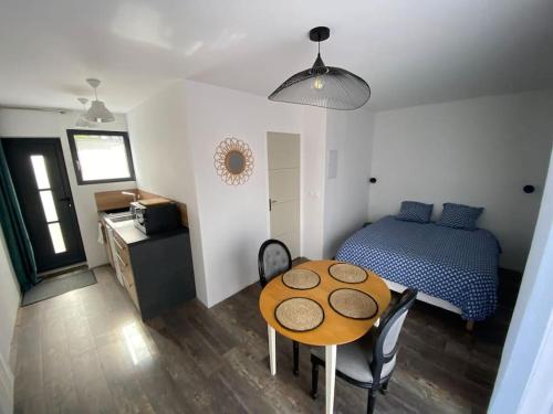 een kamer met een tafel en een bed en een slaapkamer bij L'Orée du Golf, studio 2 in Mont-Saint-Aignan