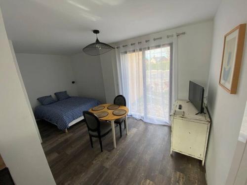 sypialnia ze stołem, łóżkiem i telewizorem w obiekcie L'Orée du Golf, studio 2 w mieście Mont-Saint-Aignan