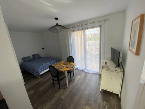 - une chambre avec une table, un lit et une télévision dans l'établissement L'Orée du Golf, studio 2, à Mont-Saint-Aignan