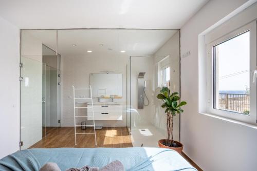 una camera da letto con pareti bianche e una grande parete di vetro di Villa Arizona - 3-bedroom house by the sea a El Médano