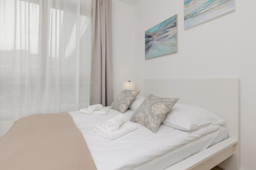 Una cama blanca con dos almohadas encima. en Oś Królewska - Comfortable Apartment in Wilanów en Varsovia