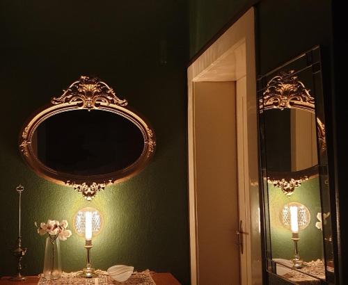 a bathroom with a mirror and a table with a lamp at Maisonette Elisabeth in Trier