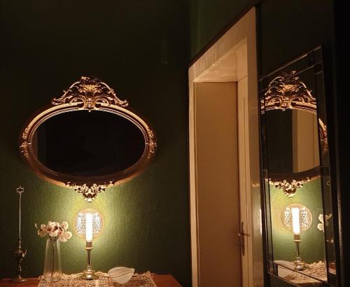 een badkamer met een spiegel en een tafel met een lamp bij Maisonette Elisabeth in Trier