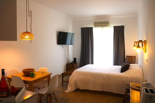 una camera da letto con un letto, un tavolo e una finestra di Sunrise Apartmento Ribeira d'Ilhas Ericeira a Ericeira
