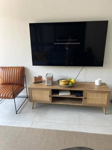 a television sitting on top of a wooden entertainment center at Utopia apartment *top location* in Tel Aviv