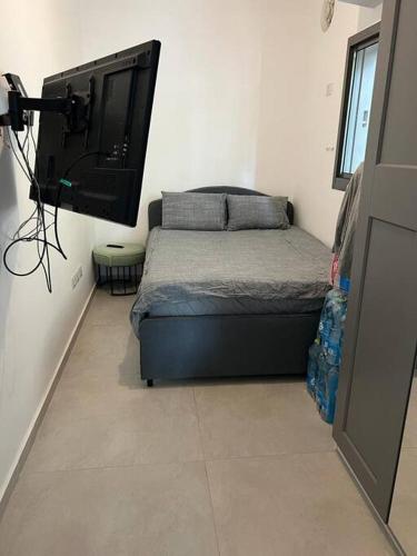 a bedroom with a bed and a flat screen tv at Utopia apartment *top location* in Tel Aviv