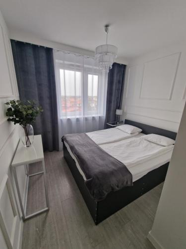 una camera da letto con un letto grande e un tavolo di 89 - Apartamenty Siedlce - Nowy apartament przy ul. Rakowieckiej a Siedlce