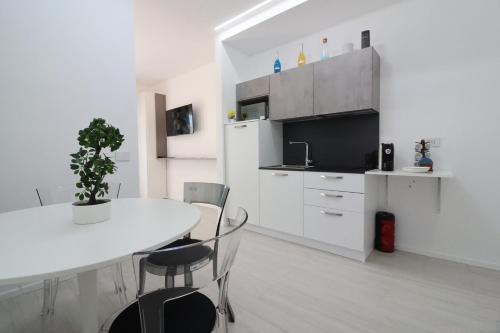a white kitchen with a white table and chairs at Ad un passo dal mare in Bari