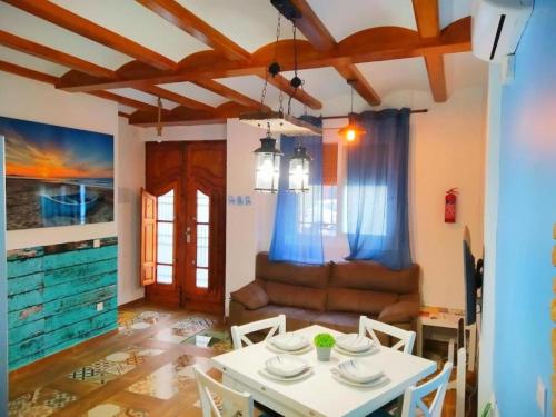 ein Wohnzimmer mit einem Tisch und einem Sofa in der Unterkunft Casa ideal para familias con patio y 3 baños in Valencia