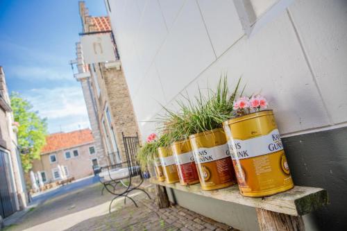 tres recipientes sentados en un banco con flores en ellos en Pension B&B Pluk, en Zierikzee