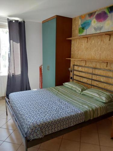 Schlafzimmer mit einem Bett mit einem Kopfteil aus Holz in der Unterkunft La casa di Alyss in Bergamo