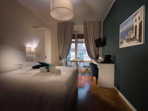 a bedroom with a bed and a desk and a window at Attico 195 in Salerno