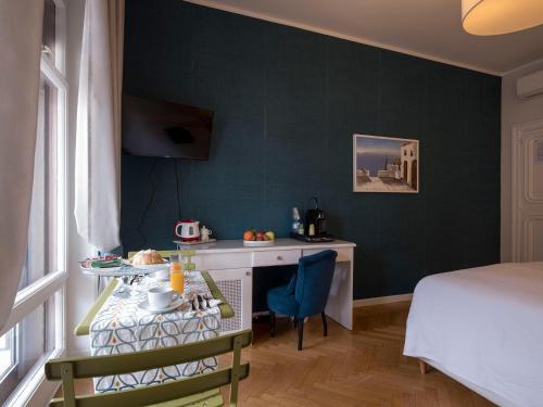 a room with a table and a bed and a desk at Attico 195 in Salerno