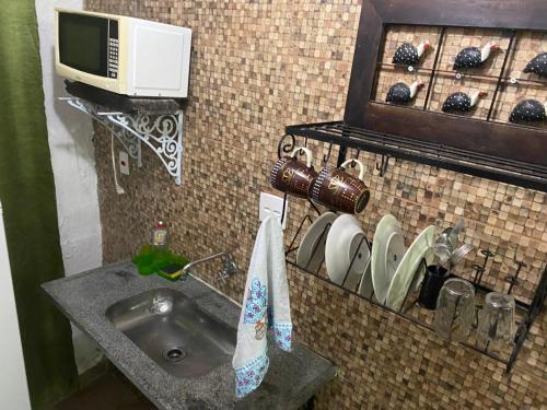 uma casa de banho com um lavatório e um micro-ondas em Rio Natureza apart 106 no Rio de Janeiro