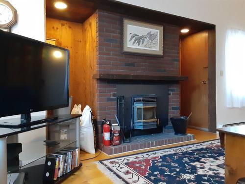 a living room with a brick fireplace with a tv at Leslie's Retreat in Campton