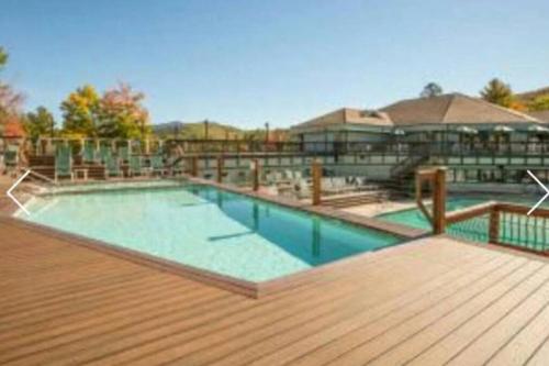 una piscina en una terraza con una terraza de madera en Leslie's Retreat, en Campton