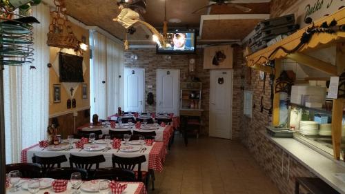 a dining room with tables with red and white tablecloths at Patkó fogadó in Hajdúszoboszló