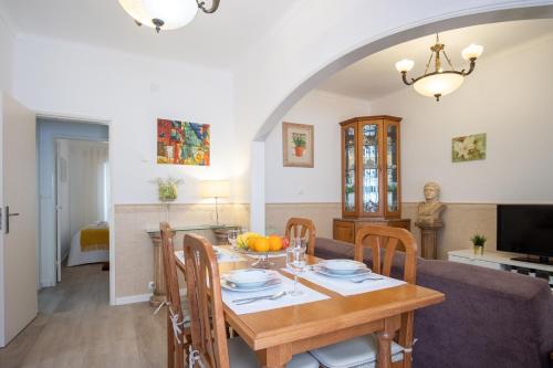 a dining room and living room with a table and chairs at casa saloia in Nazaré