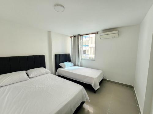 1 dormitorio con 2 camas y ventana en Apartamento 3 habitaciones Palanoa Rodadero - By Bedviajes, en Santa Marta