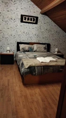a bedroom with a bed and a brick wall at Casa da Emilia do Gerês in Outeiro
