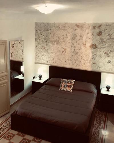 ein Schlafzimmer mit einem Bett und zwei Nachttischen in der Unterkunft Casa vacanze Ni Micheli in Naro