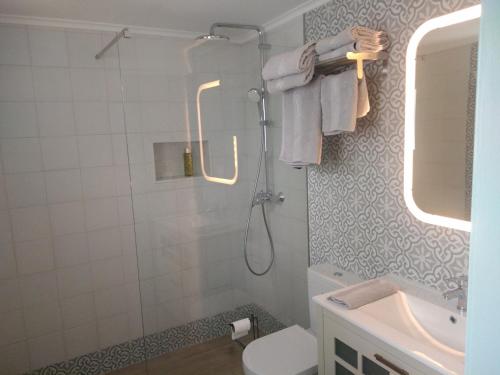 uma casa de banho com um chuveiro, um WC e um lavatório. em Casa 16 em Tavira