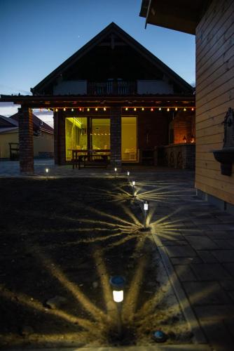 a building with lights in the middle of a patio at Benige vendégház in Demjén