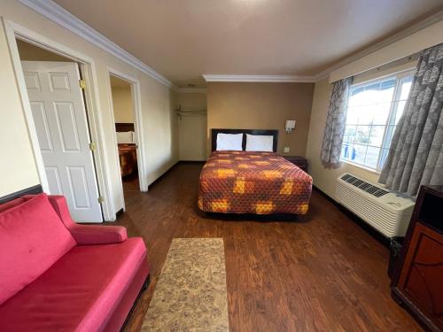 1 dormitorio con cama, sofá y ventana en Lamplighter Motel Clearlake, en Clearlake