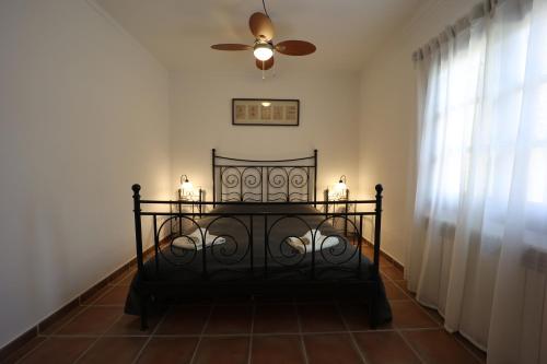 een slaapkamer met een bed en een plafondventilator bij Chalet Tres Mares, Cala Millor in Son Servera