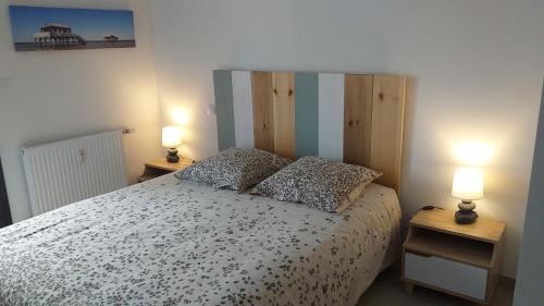1 dormitorio con 1 cama y 2 lámparas en las mesas en Bel appartement , à 2km du bassin d'Arcachon, en La Teste-de-Buch