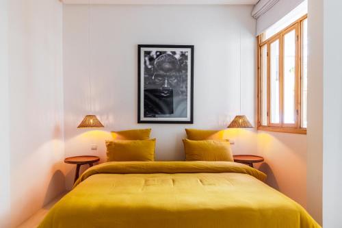 a bedroom with a yellow bed and two windows at Pure House Marrakech in Marrakech