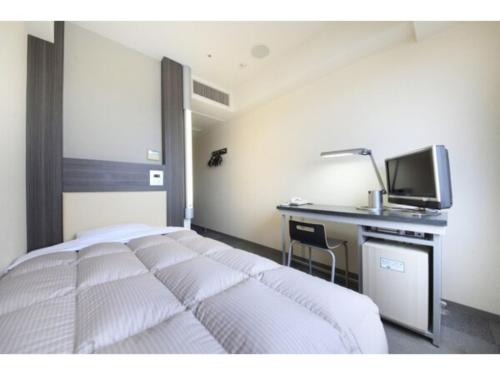 1 dormitorio con 1 cama y escritorio con TV en R & B Hotel Kamata Higashiguchi - Vacation STAY 38816v, en Tokio