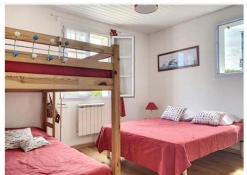 1 Schlafzimmer mit 2 Etagenbetten mit roter Bettwäsche in der Unterkunft l'Echo des Vagues in Foulerot