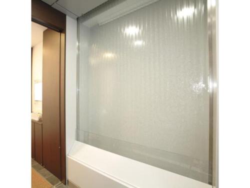 東京的住宿－R & B Hotel Kamata Higashiguchi - Vacation STAY 38814v，带浴缸的浴室内的玻璃窗