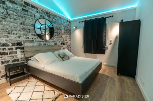 - une chambre avec un lit et un mur en briques dans l'établissement Paradisier, à Villars-les-Dombes