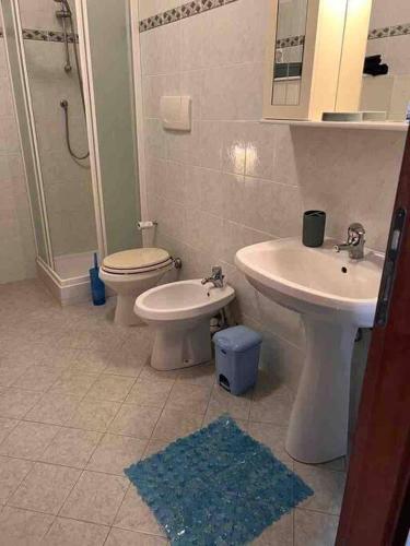 a bathroom with a toilet and a sink and a shower at Appartamento tranquillo con patio e piscina in La Caduta