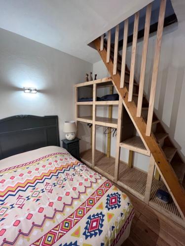 een slaapkamer met een bed en een houten trap bij Louis Maissa in Saint-Martin-Vésubie