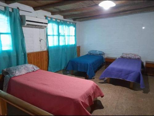2 camas en una habitación con sábanas azules y rojas en El salto en San Rafael