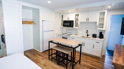 a kitchen with white cabinets and a wooden table at Devon Shores in Clearwater Beach