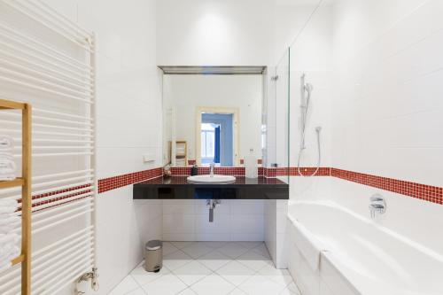 uma casa de banho branca com um lavatório e um espelho em Grand Viennese Residence em Viena