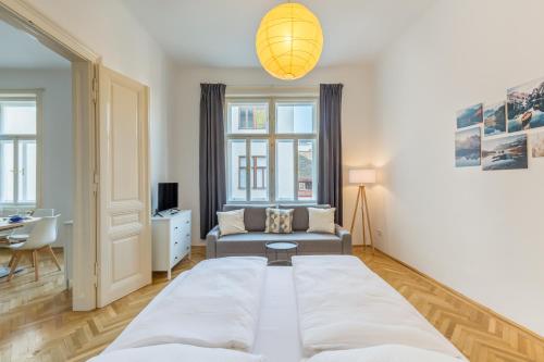 um quarto com uma cama grande e um sofá em Grand Viennese Residence em Viena