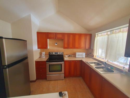 a kitchen with wooden cabinets and a stainless steel refrigerator at Executive Airport Apartment Guatemala in Guatemala